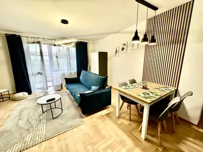 a living room with a table and a couch at Blue Zone Apartment with FREE Parking, Balcony and Garden in Kraków