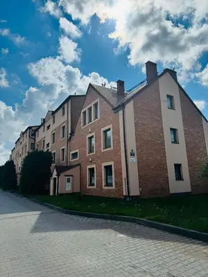 a large brick building on the side of a street at Blue Zone Apartment with FREE Parking, Balcony and Garden in Kraków