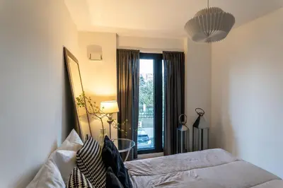 a bedroom with a bed and a large window at luxusowy apartament w centrum Krakowa in Kraków