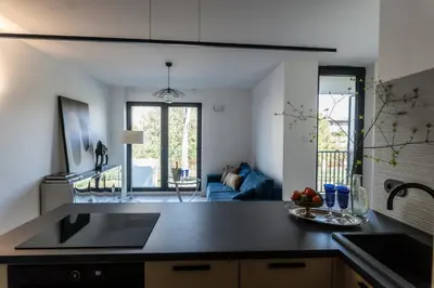 a kitchen with a sink and a living room at luxusowy apartament w centrum Krakowa in Kraków