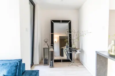 a hallway with a mirror and a blue couch at luxusowy apartament w centrum Krakowa in Kraków