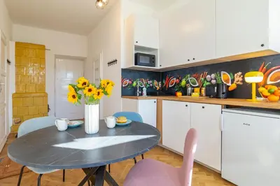 a kitchen with a table and chairs and a kitchen with white cabinets at Alma in Cracow! 2 room by the gate to Old Town in Kraków