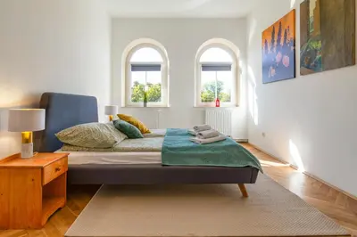 a bedroom with a bed and two windows at Alma in Cracow! 2 room by the gate to Old Town in Kraków