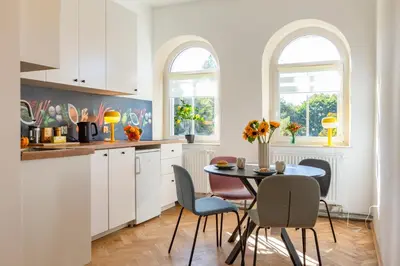 a kitchen with white cabinets and a table and chairs at Alma in Cracow! 2 room by the gate to Old Town in Kraków