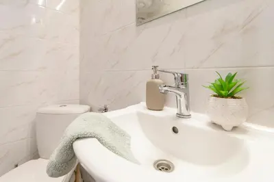 a white bathroom with a sink and a toilet at Alma in Cracow! 2 room by the gate to Old Town in Kraków