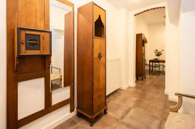 a bedroom with a large wooden cabinet with a mirror at ARTEon with terrace in Kraków