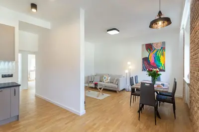 a living room with a couch and a dining room at Bright Rose in Kraków