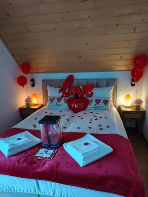 a bed with red hearts and balloons on it at MICHAŁÓWKA - Domek w Górach przy Lesie - Energylandia in Targanice