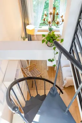 a living room with a chair and a fireplace at Charming 2-level loft in central Cracow in Kraków
