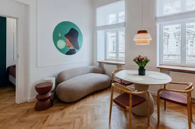 a living room with a table and a couch at Colourful apartments Siemiradzkiego Street - City Centre in Kraków
