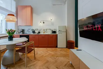 a kitchen with a table and a refrigerator at Colourful apartments Siemiradzkiego Street - City Centre in Kraków
