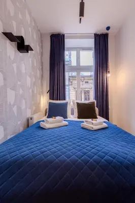 a bedroom with a blue bed with two pillows on it at Colourful apartments Siemiradzkiego Street - City Centre in Kraków