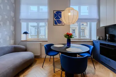 a kitchen and living room with a table and chairs at Colourful apartments Siemiradzkiego Street - City Centre in Kraków