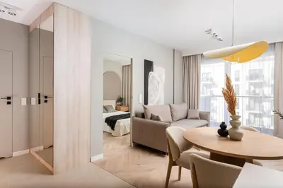 a living room with a table and a bedroom at Sandstone Apartament - homfi Collection in Kraków
