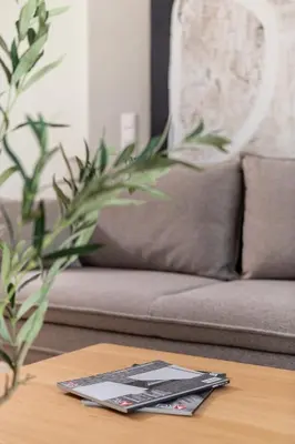 a magazine sitting on a table in front of a couch at Sandstone Apartament - homfi Collection in Kraków