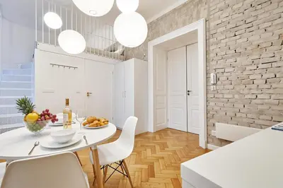 a kitchen and dining room with a white table and chairs at Cracow Fancy Brick #2 - Old Town in Kraków