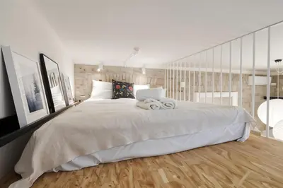 a bedroom with a large white bed and wooden floors at Cracow Fancy Brick #2 - Old Town in Kraków