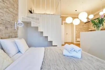 a white bed in a room with a staircase at Cracow Fancy Brick #2 - Old Town in Kraków