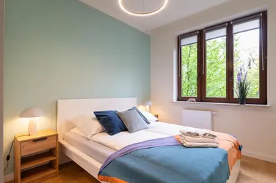 a bedroom with a large bed and a window at Golden hour, 2 bedroom, with underground parking in Kraków
