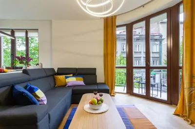 a living room with a blue couch and a table at Golden hour, 2 bedroom, with underground parking in Kraków