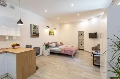 a bedroom with a bed and a kitchen in a room at Great base to explore Cracow in Kraków