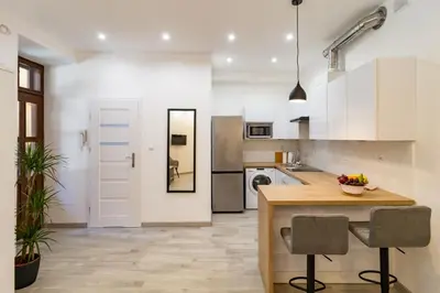 a living room with a couch and a kitchen at Great base to explore Cracow in Kraków