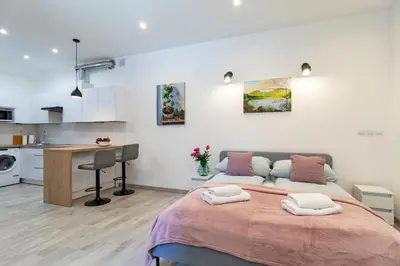 a kitchen with white cabinets and a table and chairs at Great base to explore Cracow in Kraków