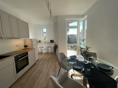 a kitchen and dining room with a table and chairs at Leo Apartments Kraków in Kraków