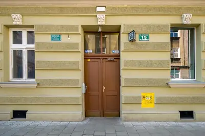 a yellow building with a brown door and windows at Mint&Jade studio A in Kraków