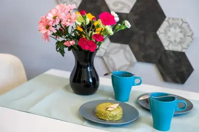 a table with a vase of flowers and a plate of food at Mint&Jade studio A in Kraków