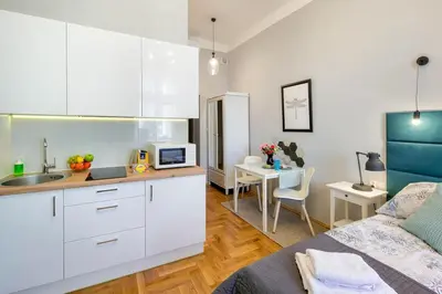 a kitchen with white cabinets and a sink in a room at Mint&Jade studio A in Kraków