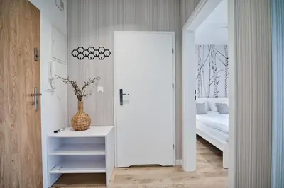 a bedroom with a white door leading to a bed at Jaśminowy Las by Housine in Zator