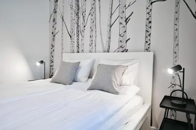 a bedroom with a white bed with two pillows at Jaśminowy Las by Housine in Zator