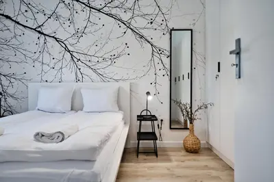 a bedroom with a bed with a tree mural on the wall at Jaśminowy Las by Housine in Zator