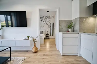 a kitchen with white cabinets and a vase on the floor at Jaśminowy Las by Housine in Zator