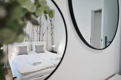 a bedroom with a white bed and a mirror at Jaśminowy Las by Housine in Zator