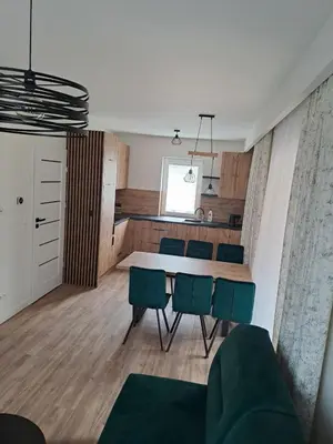 a kitchen and dining room with a table and chairs at Domek letniskowy Leśne Zacisze in Słopnice