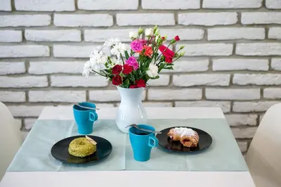 a table with two plates of food and a vase with flowers at Mint&Jade studio B in Kraków