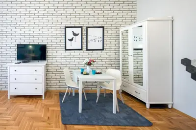 a dining room with a white table and chairs at Mint&Jade studio B in Kraków