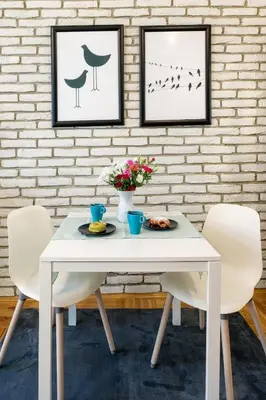 a white table and chairs in a room with a brick wall at Mint&Jade studio B in Kraków