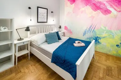 a bedroom with a white bed with a blue comforter at Mint&Jade studio C in Kraków
