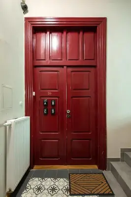 a red door in a room with a staircase at Mint&Jade studio C in Kraków