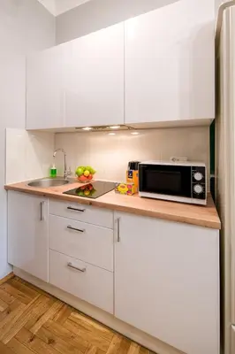 a kitchen with white cabinets and a microwave at Mint&Jade studio D in Kraków
