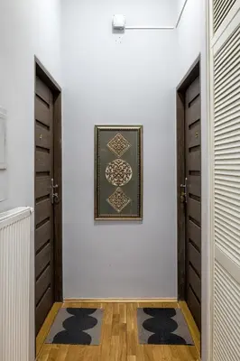 a hallway with two doors and a picture on the wall at Mint&Jade studio D in Kraków
