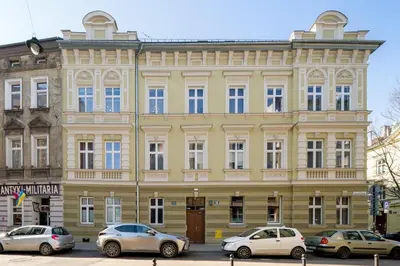 a yellow building with cars parked in front of it at Mint&Jade studio D in Kraków