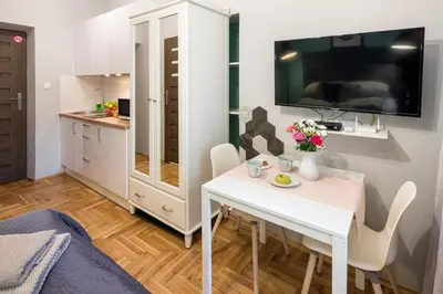 a kitchen and dining room with a white table and chairs at Mint&Jade studio D in Kraków