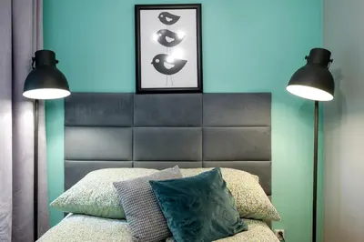 a bedroom with two lamps and a bed with a headboard at Mint&Jade studio D in Kraków