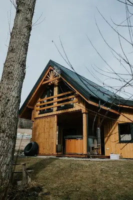a large wooden house with a black roof at Domki Pod Halą Krupowa - Domek Zawoja in Sidzina
