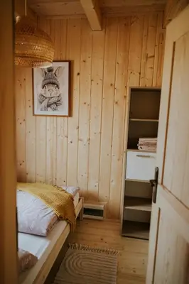 a small house with a black roof at Domki Pod Halą Krupowa - Domek Zawoja in Sidzina