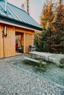 a bed in a room with a large window at Domki Pod Halą Krupowa - Domek Zawoja in Sidzina